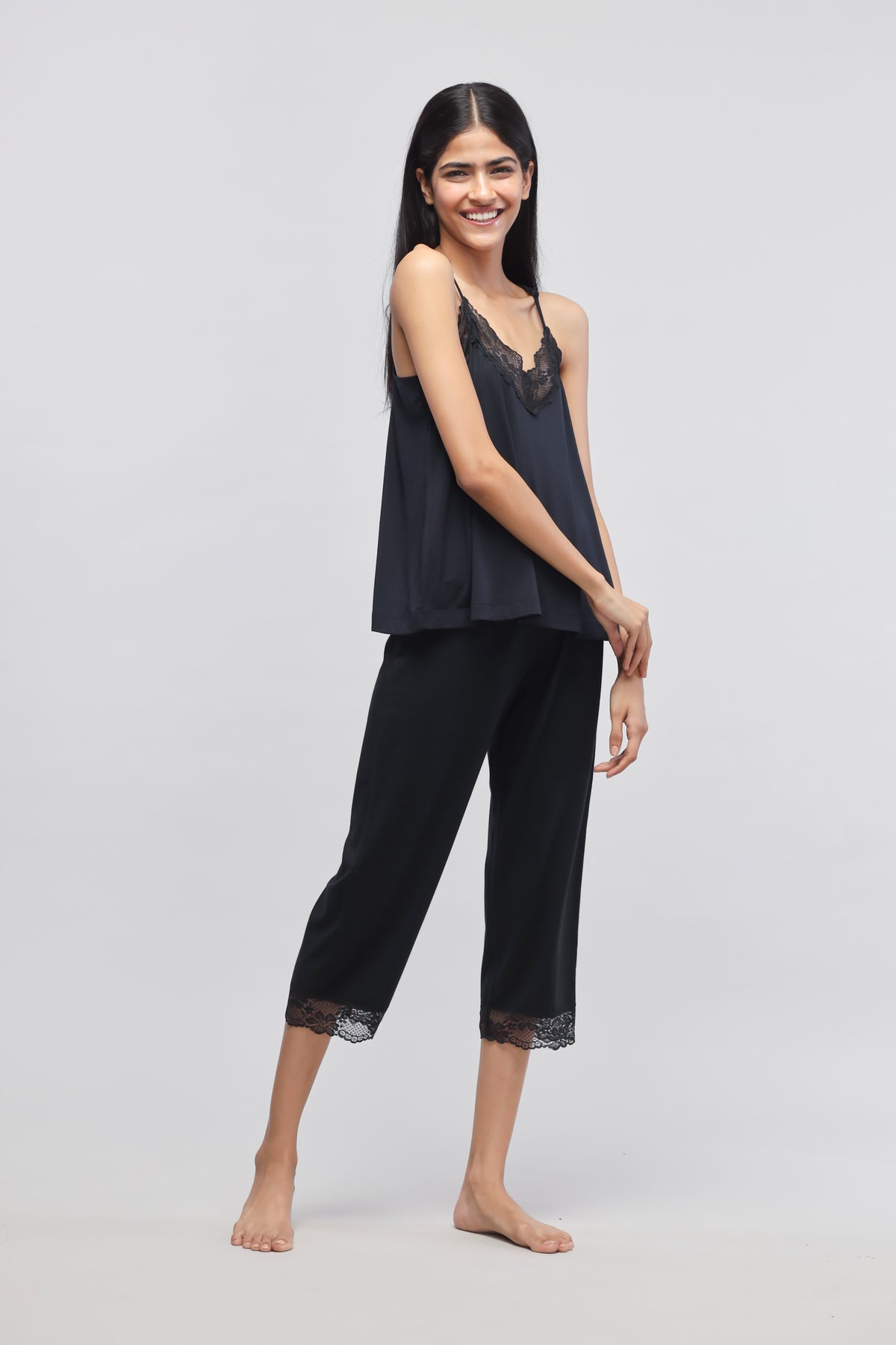 Delicate black lace tank top worn by smiling model.