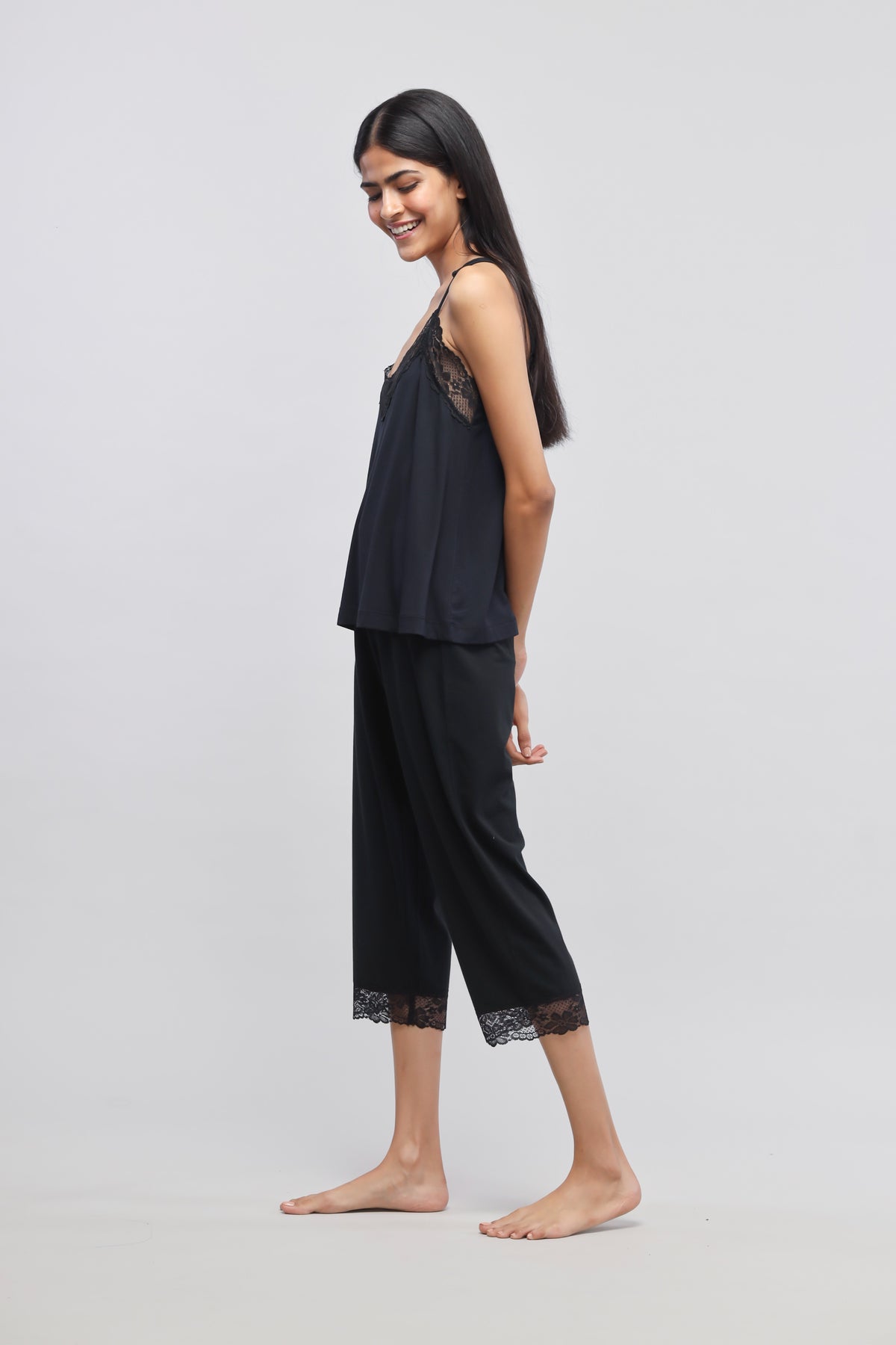 Delicate black lace tank top worn with stylish black pants.