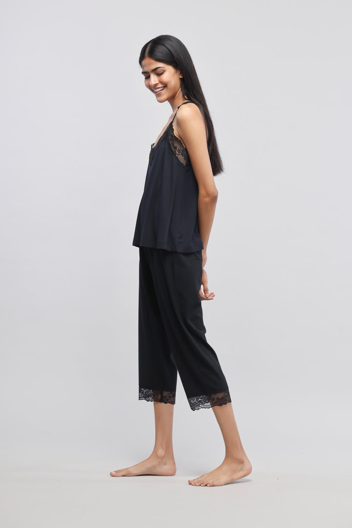 Delicate black lace tank top worn with stylish black pants.