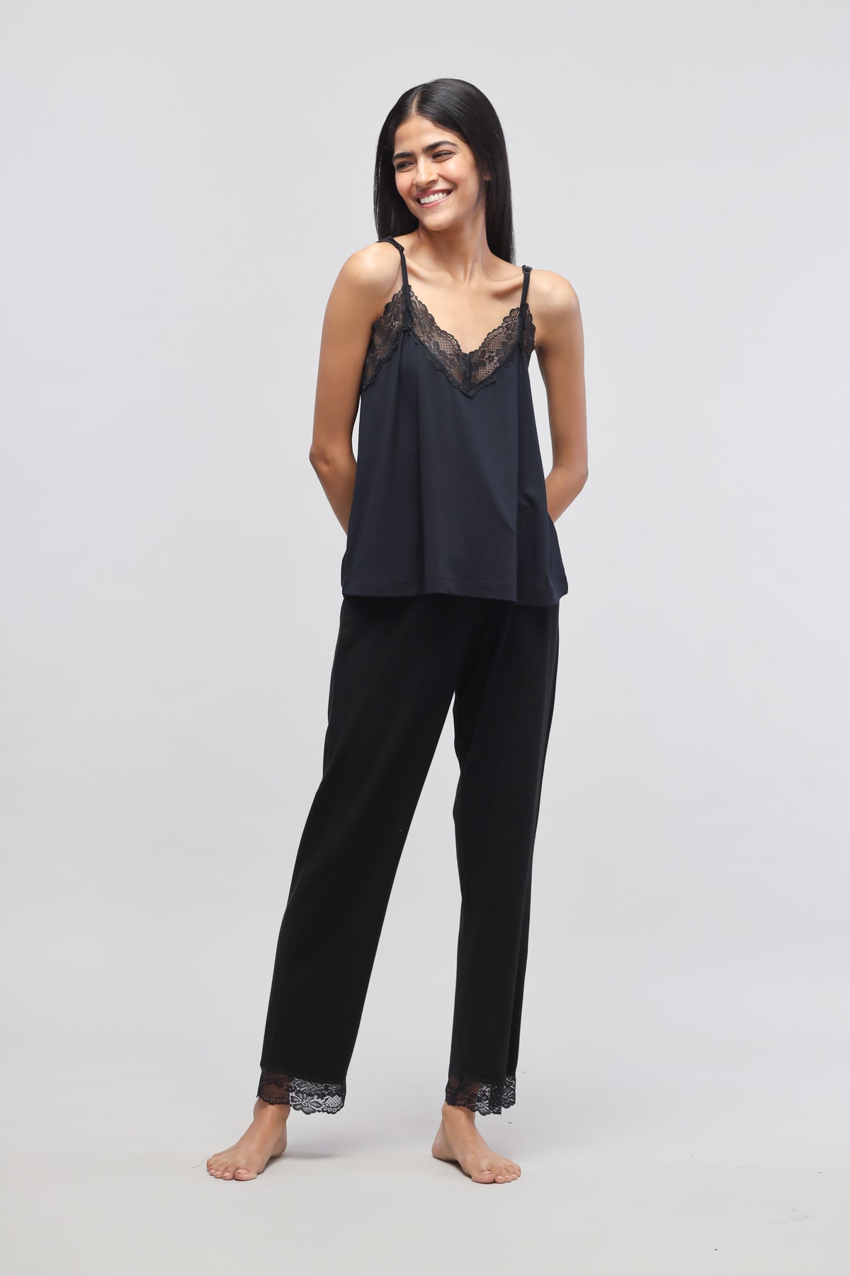 Delicate black lace tank top paired with stylish black pants.