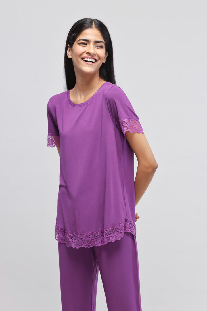 Dreamy purple lace pajama set model smiling in stylish outfit.