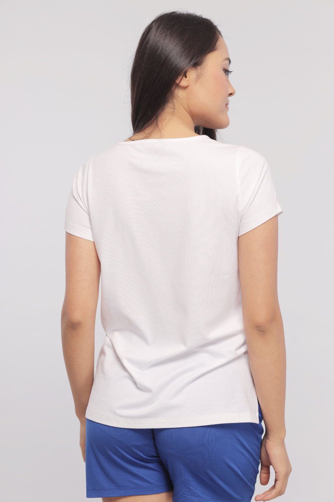 Model wearing a white monochrome shorts set from the back.