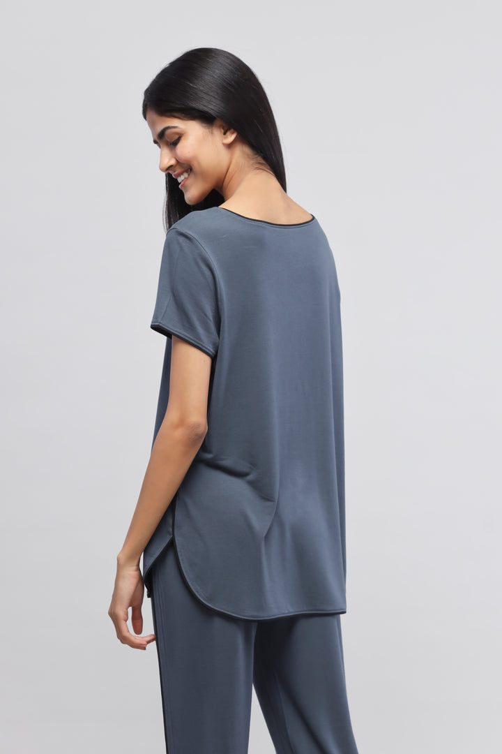 Model wearing a deep blue piping top, showcasing back view.