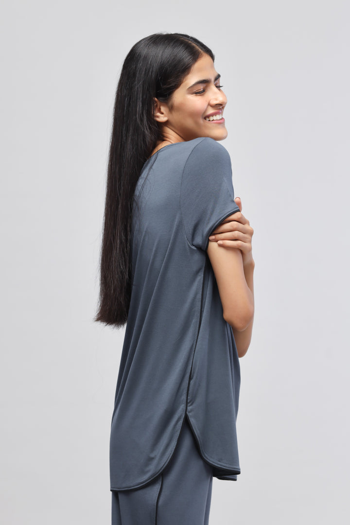 Deep Blue Piping Top modeled by a smiling woman from the side.