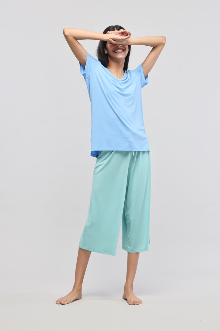 Woman wearing Aqua Culotte Set, featuring blue top and mint culottes.