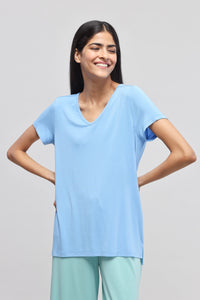 Summer blue V-neck top worn by smiling woman, casual fashion.