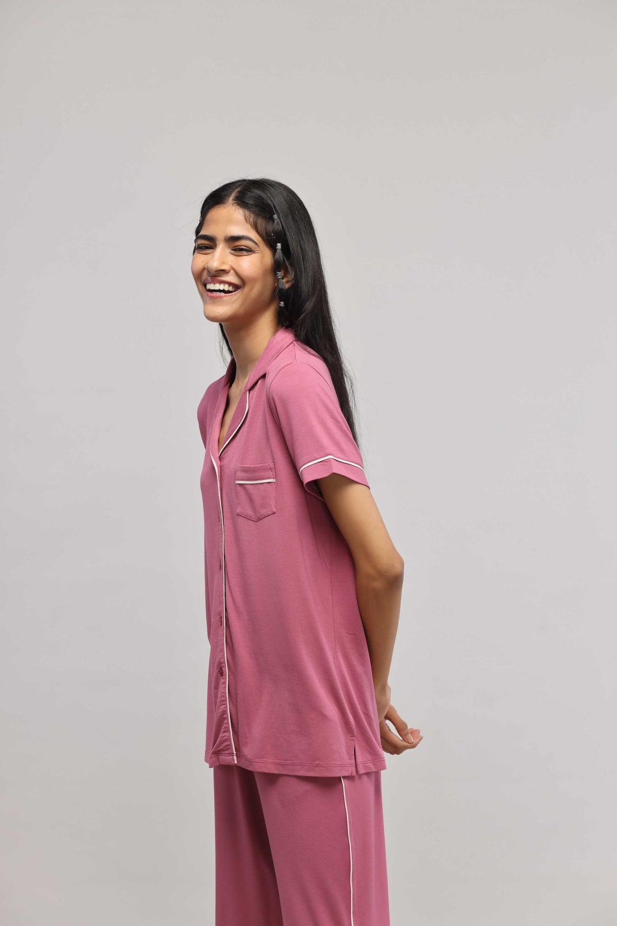Smiling model wearing rosy pink button down half sleeve top.