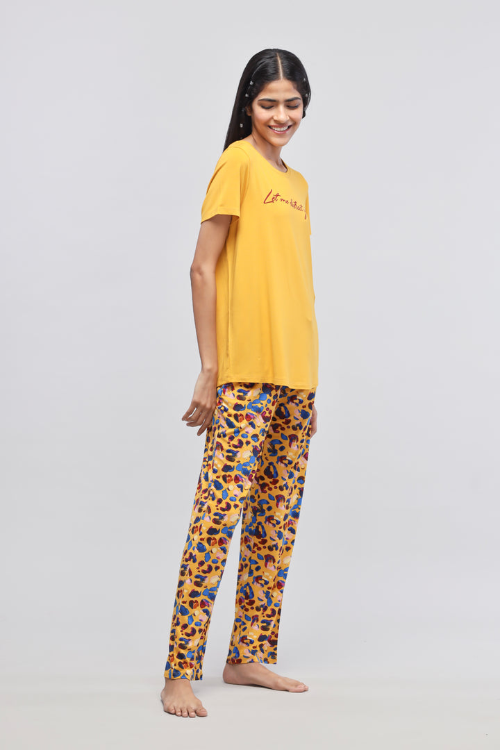 Model wearing Safari Modal Pajamas in yellow and colorful leopard print.