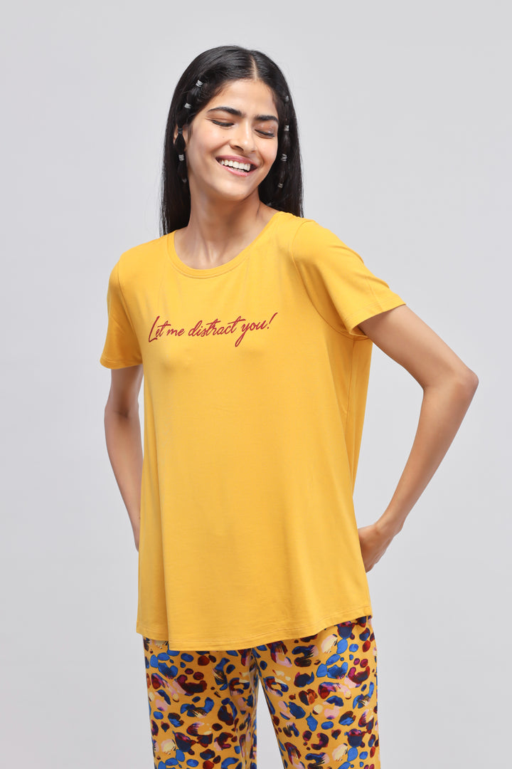 Yellow "Let Me Distract You" top worn by smiling model.