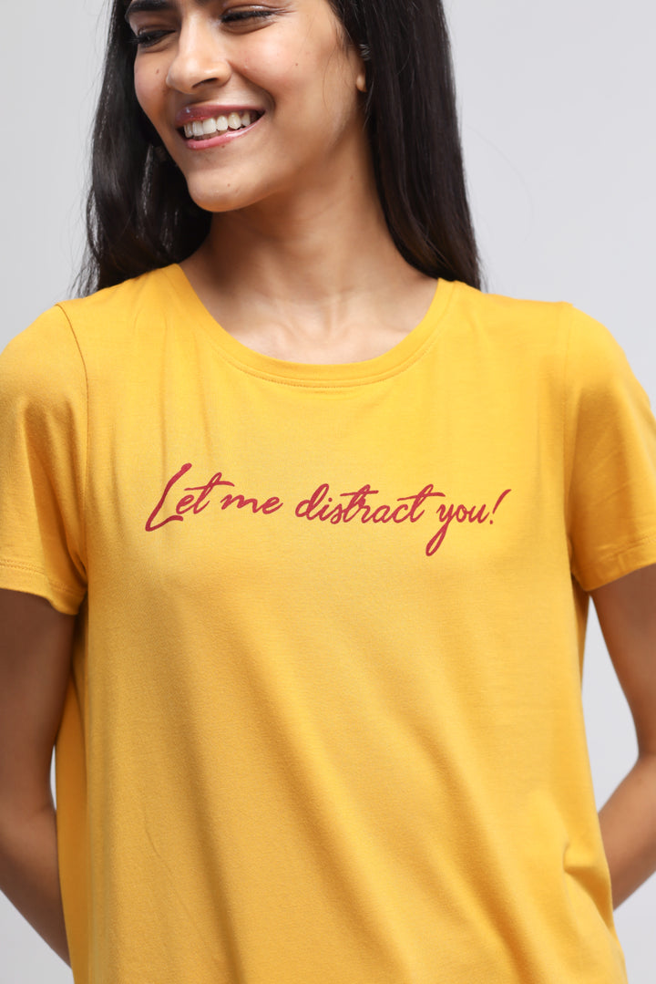 Yellow "Let Me Distract You" t-shirt worn by smiling woman.