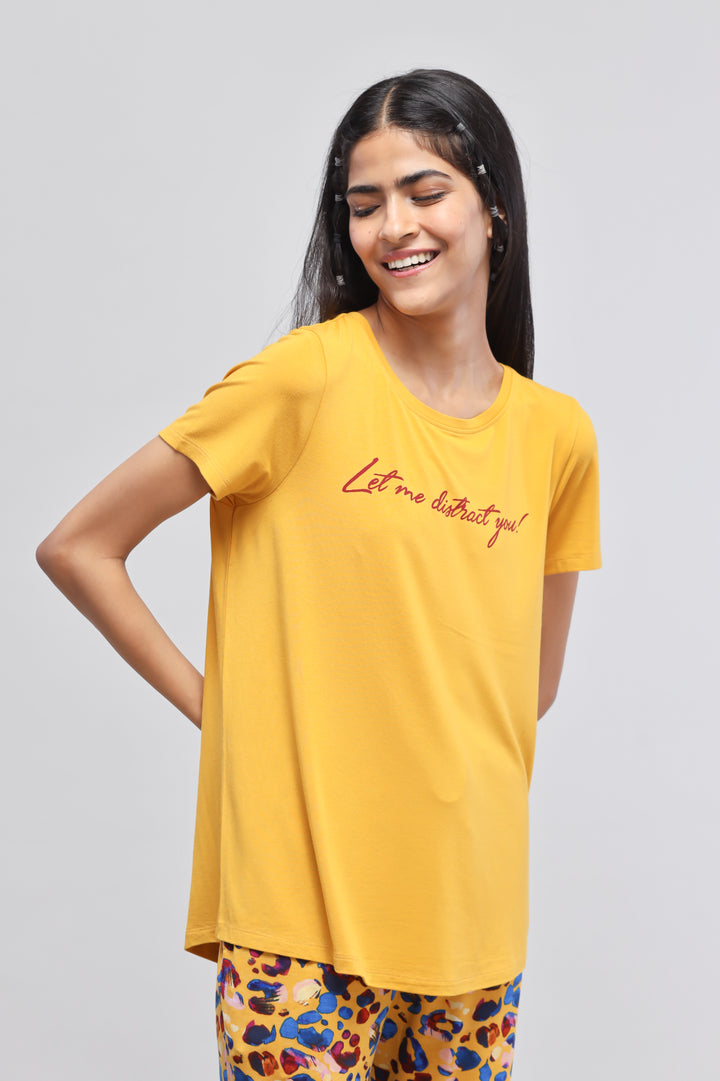 Yellow "Let Me Distract You" top worn by a smiling model.