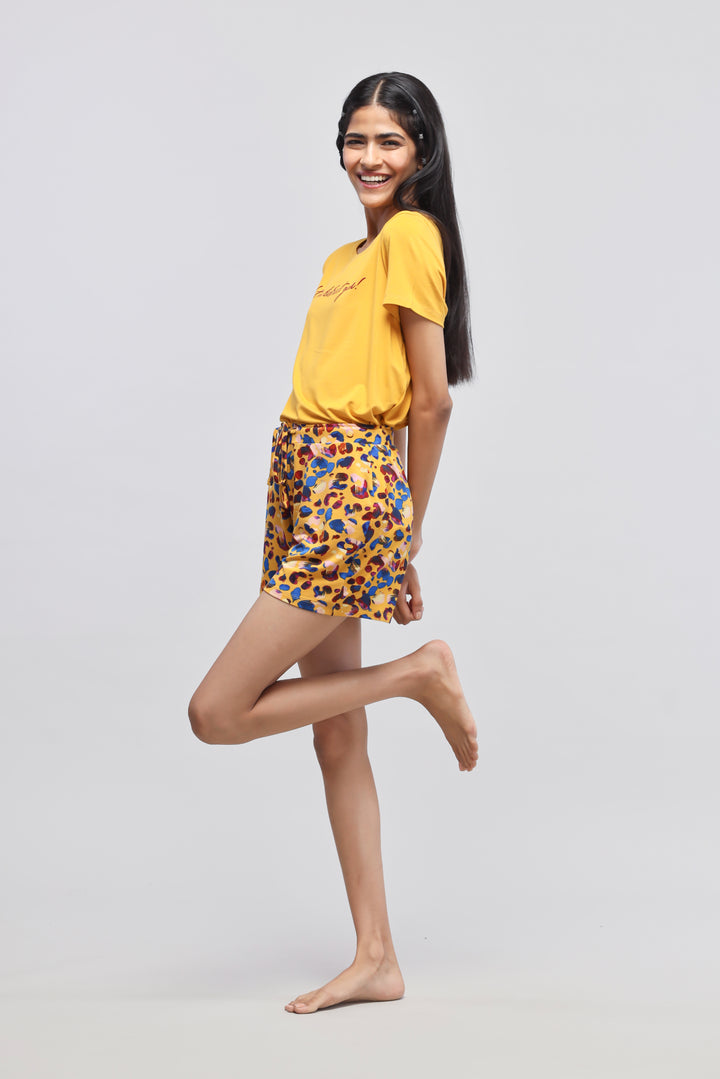 Model wearing yellow "Beautiful" tee and colorful safari modal shorts.