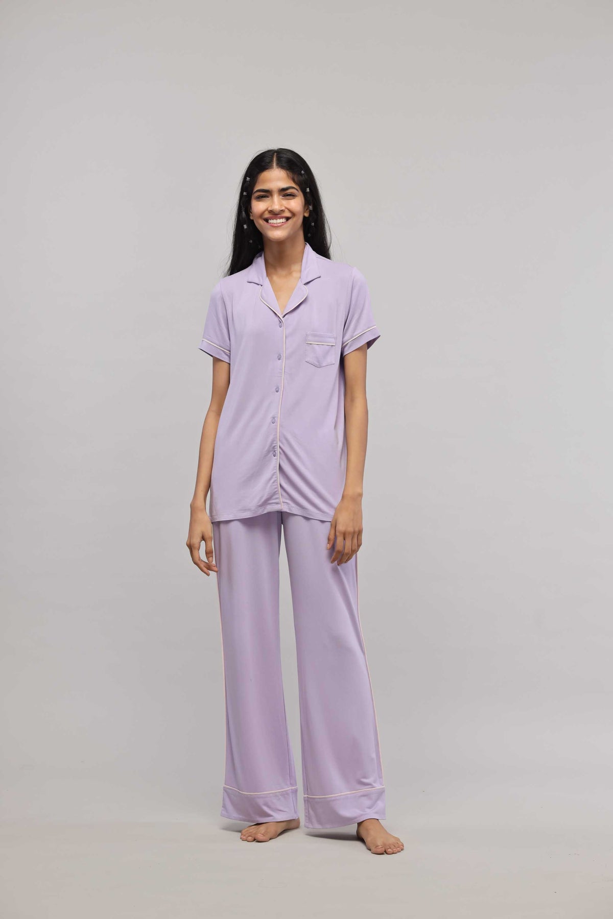 Lavender button-down half sleeve top with piping details on model.