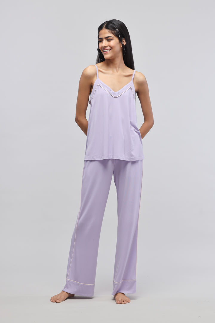Smiling woman wearing a lavender tank top and matching pants.