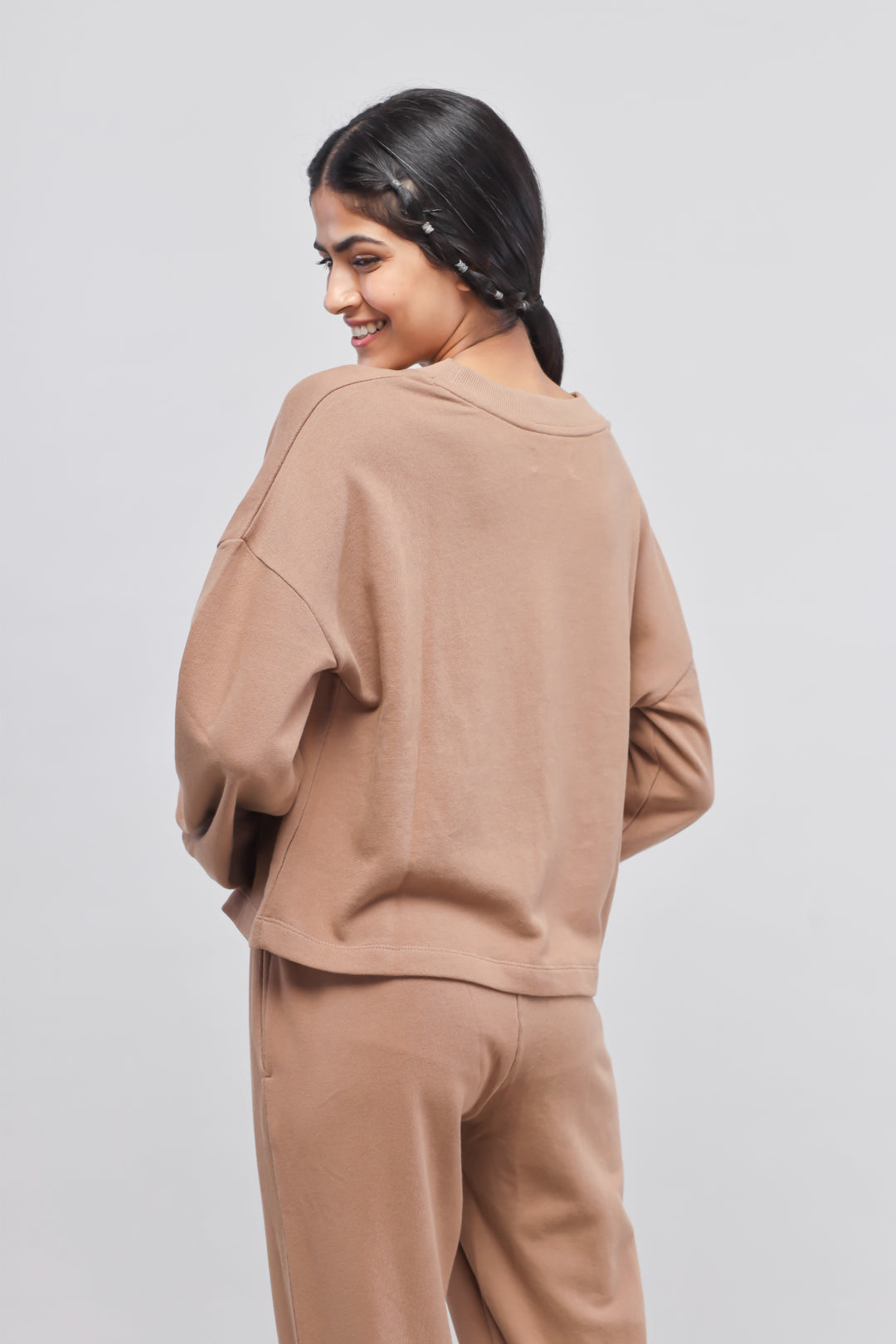 Brown terry puffed sweatshirt styled with matching bottoms, cozy fashion.