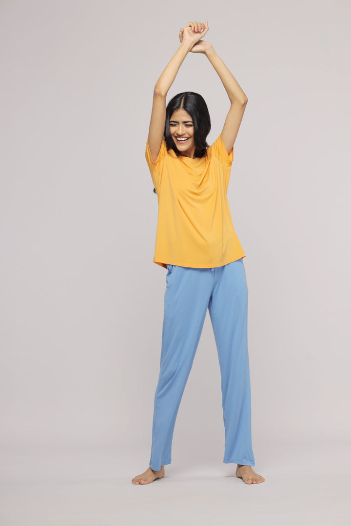 Smiling model in cozy blue lounge set with yellow top.