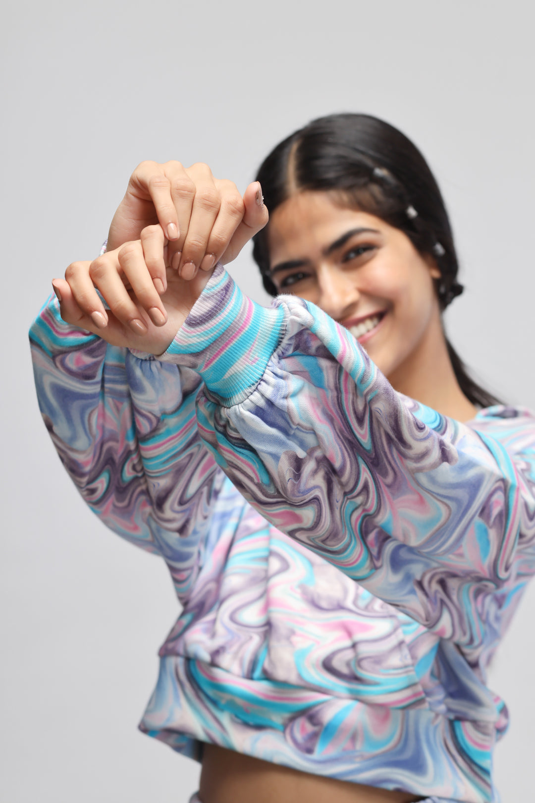 Colorful fluid hoodie co-ord set on a smiling model.