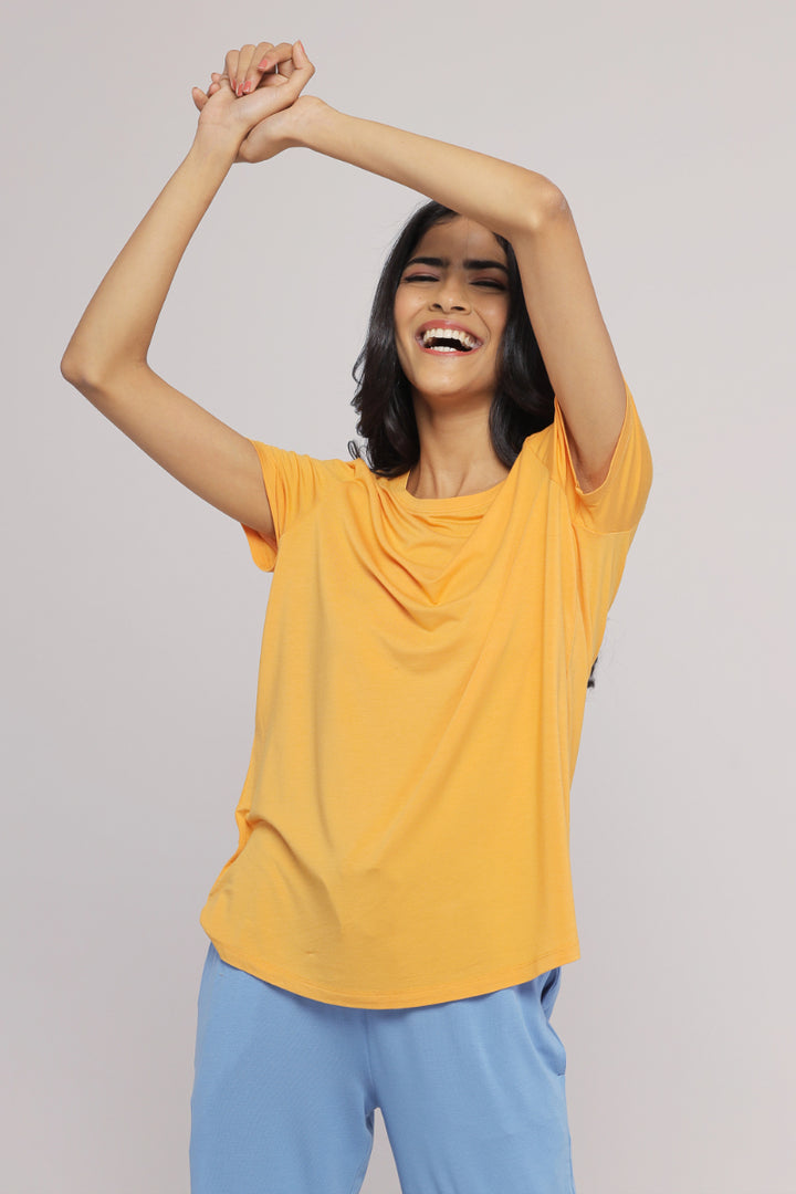 Smiling model wearing cozy blue straight lounge set with yellow top.
