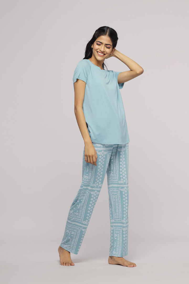 Misty Teal Top worn by smiling woman with patterned pants.