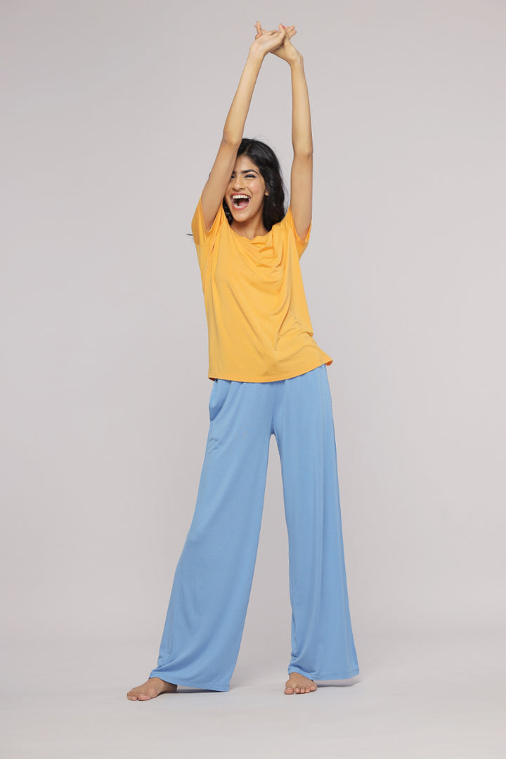 Cheerful woman wearing cozy blue flared lounge pajama set.