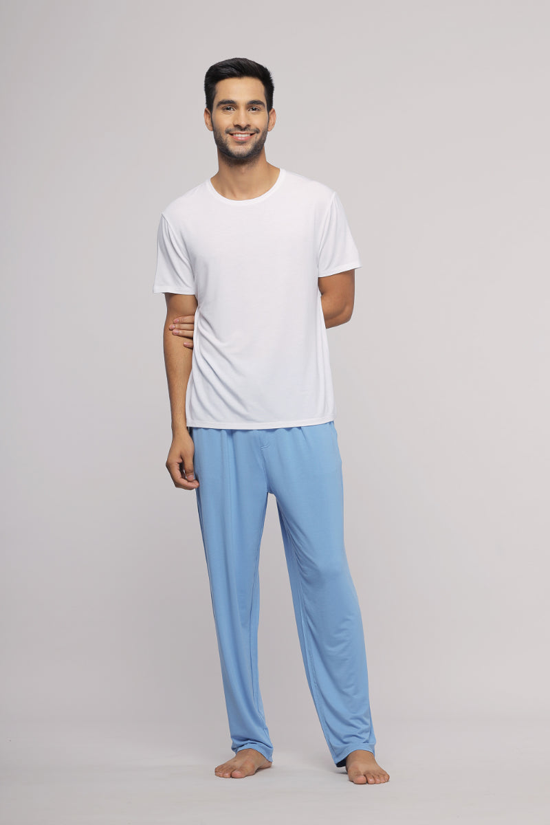 Men's white lounge t-shirt paired with blue pajama pants.