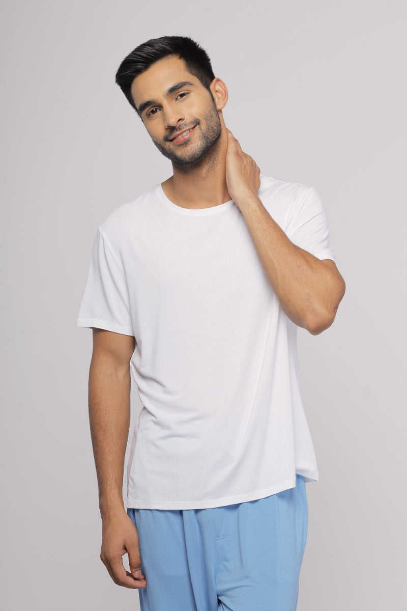 Men's white lounge T-shirt modeled by smiling man in casual wear.