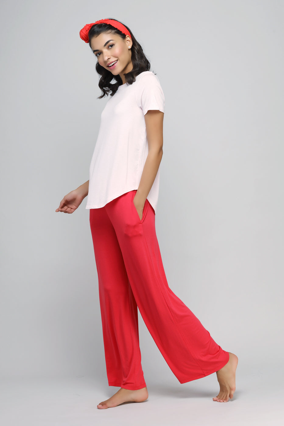 Woman in blush top and red pants, stylish casual outfit.