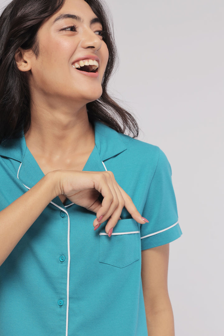 Teal half sleeve button down pajama set model smiling in soft fabric.