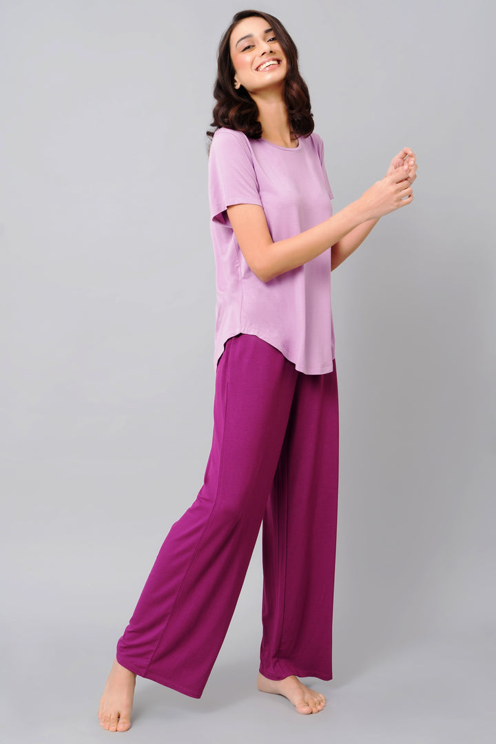Woman wearing a soothing purple top and matching pants, smiling.