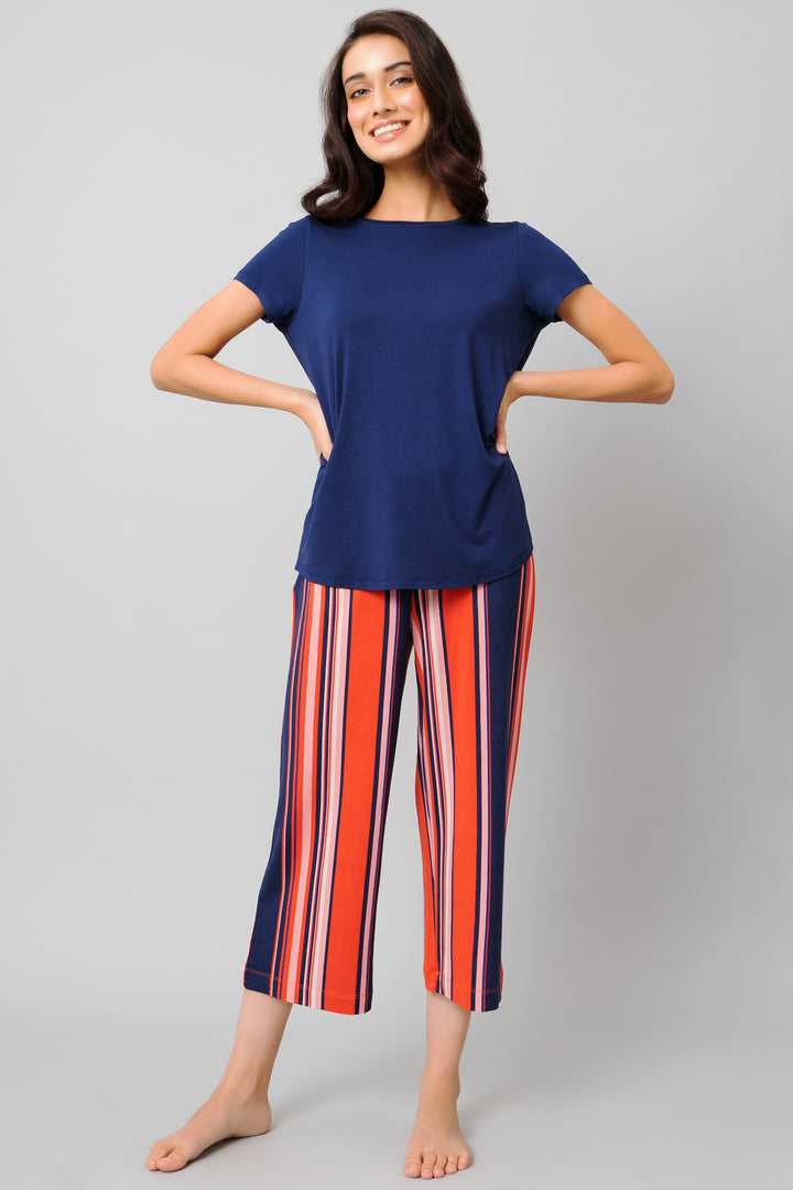 Woman wearing classic stripe capri set, featuring navy top and striped pants.