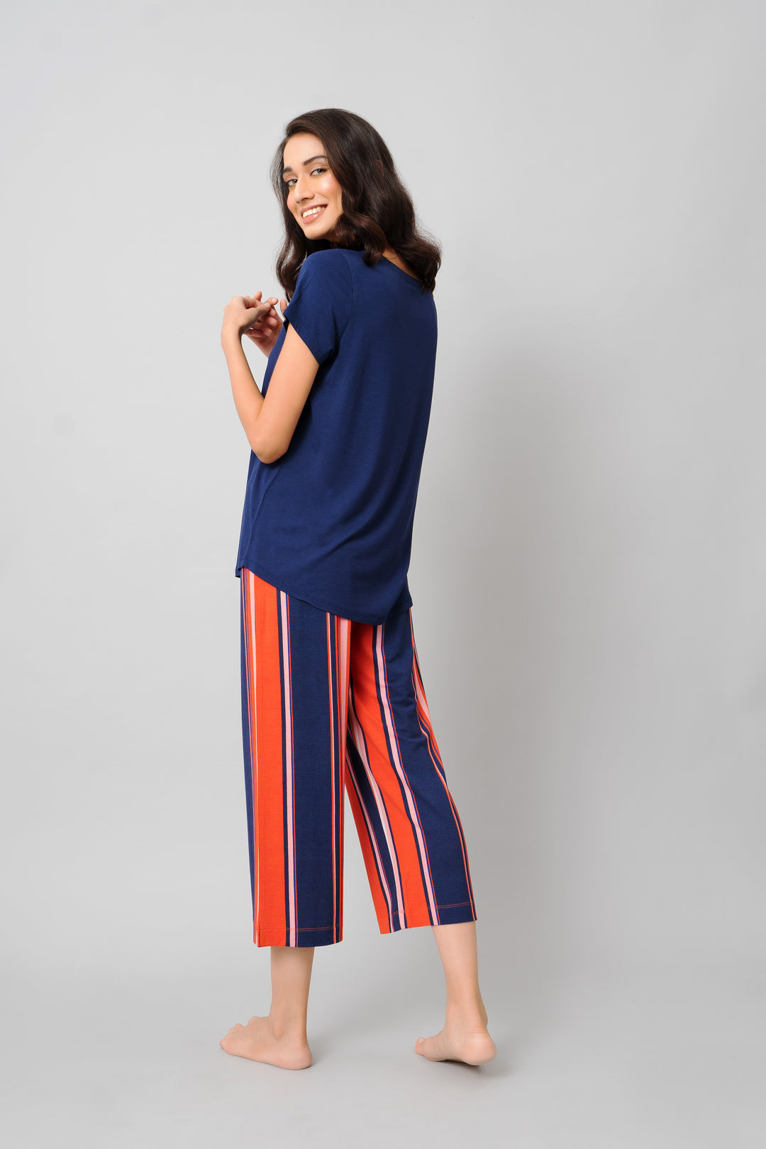 Model showcasing Classic Stripe Capri Set in navy and orange stripes.