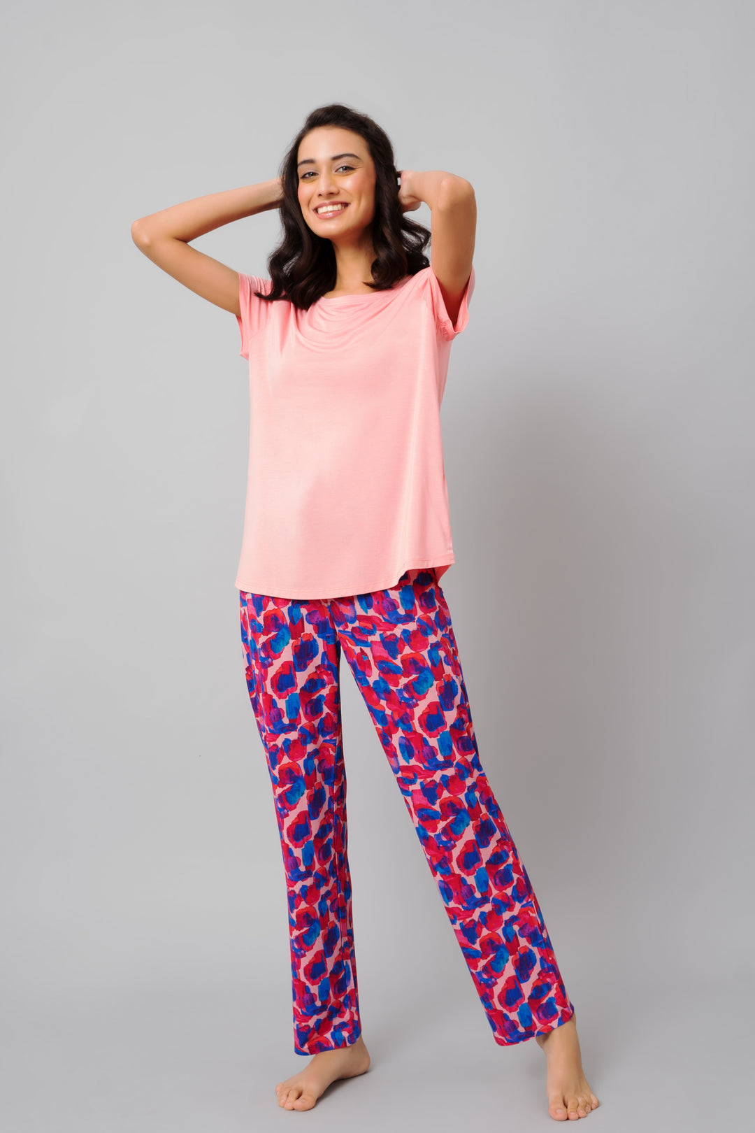 Model wearing Artsy Watercolor Pajamas in pink and colorful patterns.
