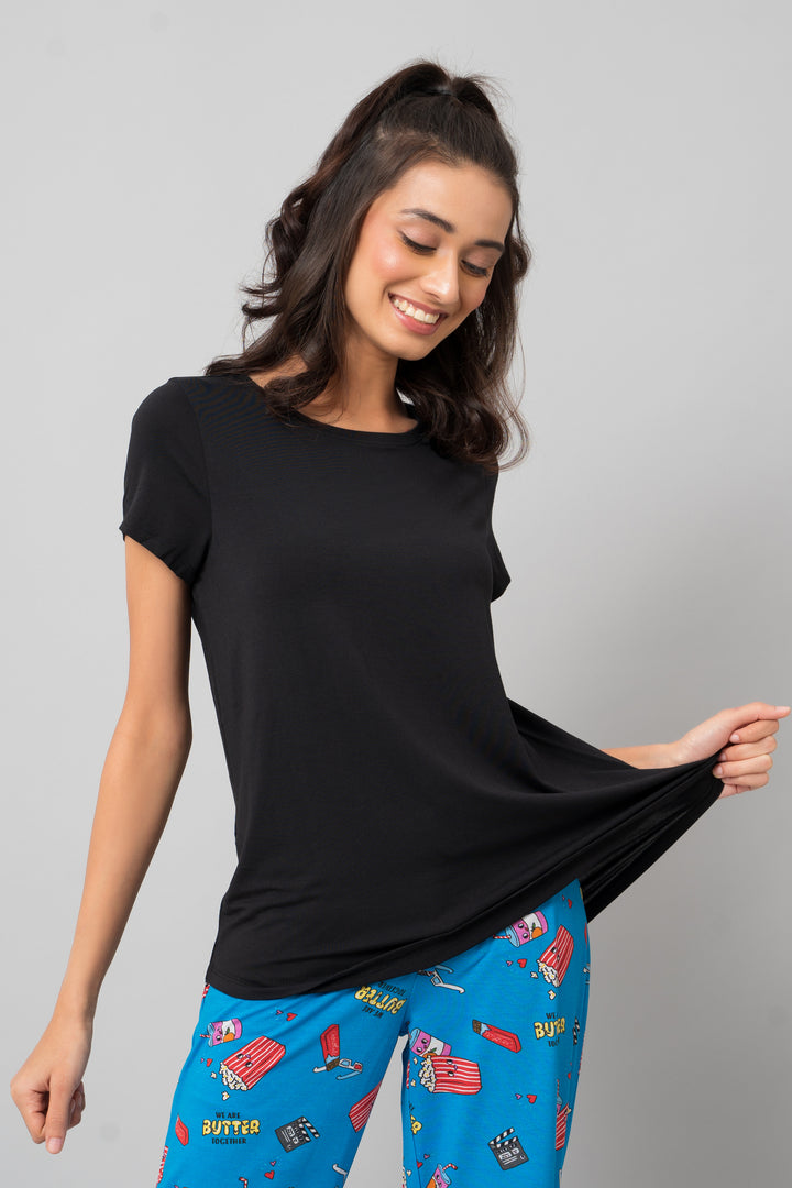 "Model wearing casual black shorts set with playful blue pajama bottoms."