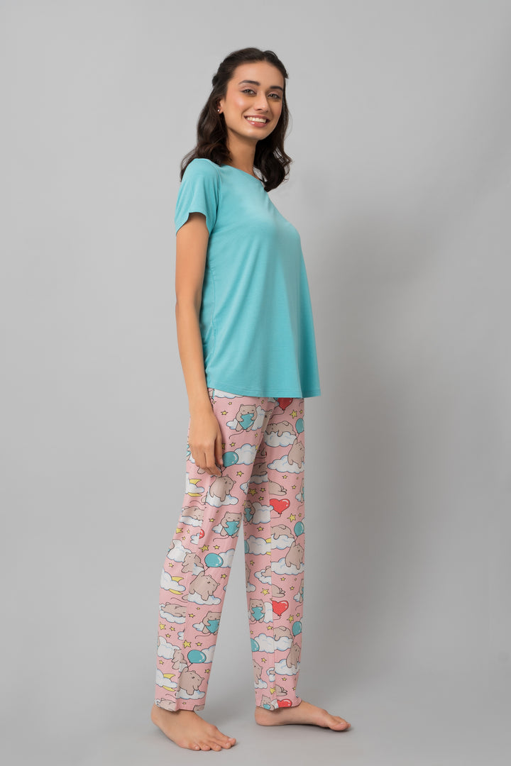 Woman wearing Dreamy Day Pajama Set with playful cloud patterns.