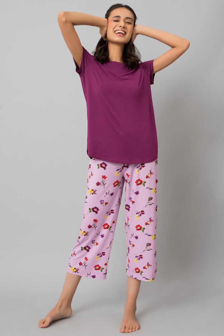 Smiling woman in Winter Romance Capri Set, purple top and floral pants.