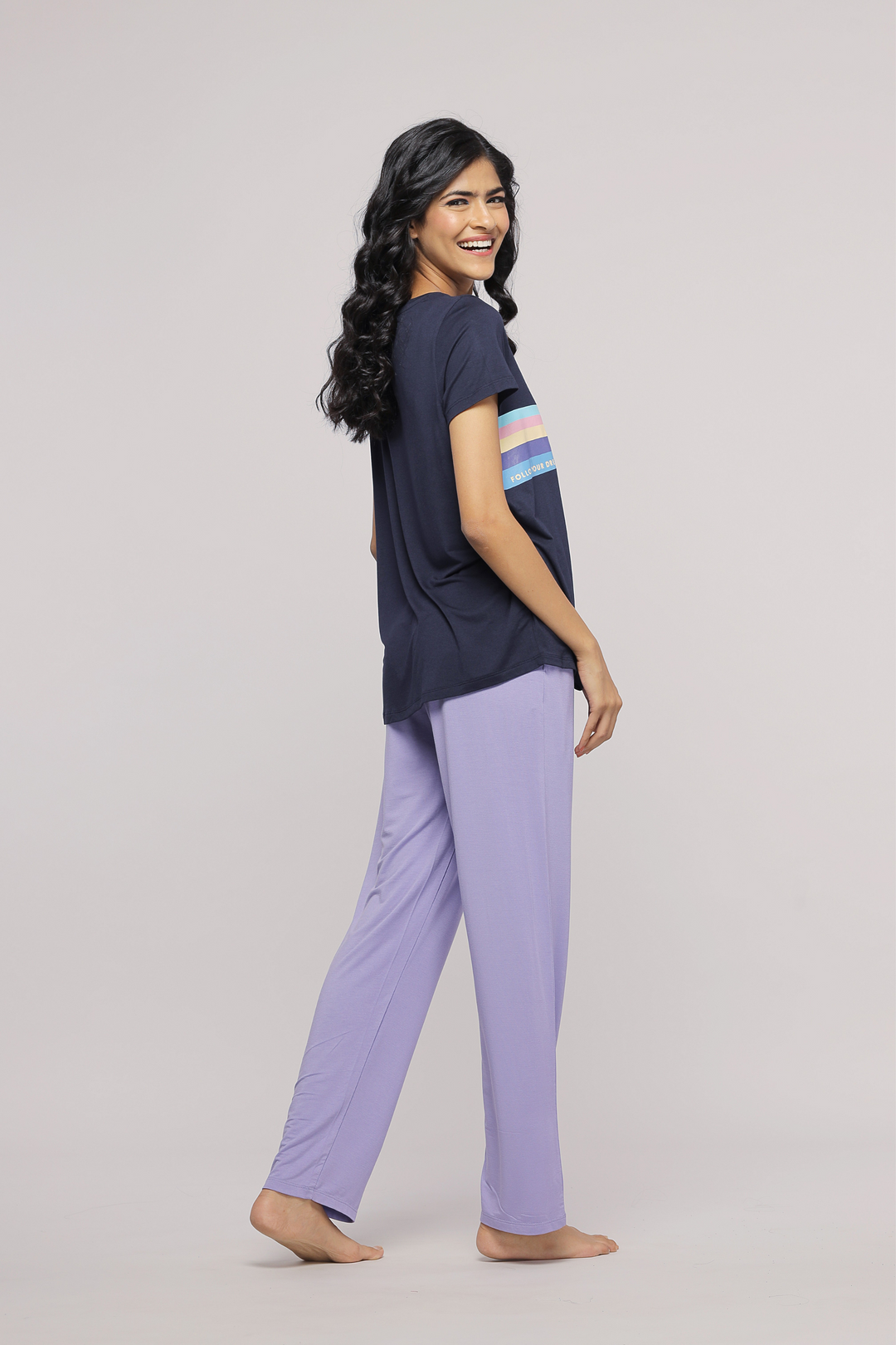 "Model wearing Follow Your Dream Top with lavender pants, smiling confidently."
