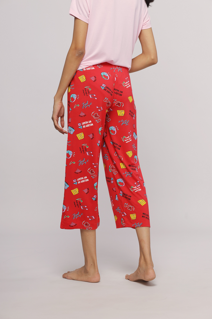 Red capri pants with music-themed prints, perfect for casual wear.