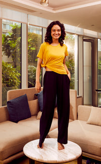Woman wearing black flared lounge pants in a stylish indoor setting.