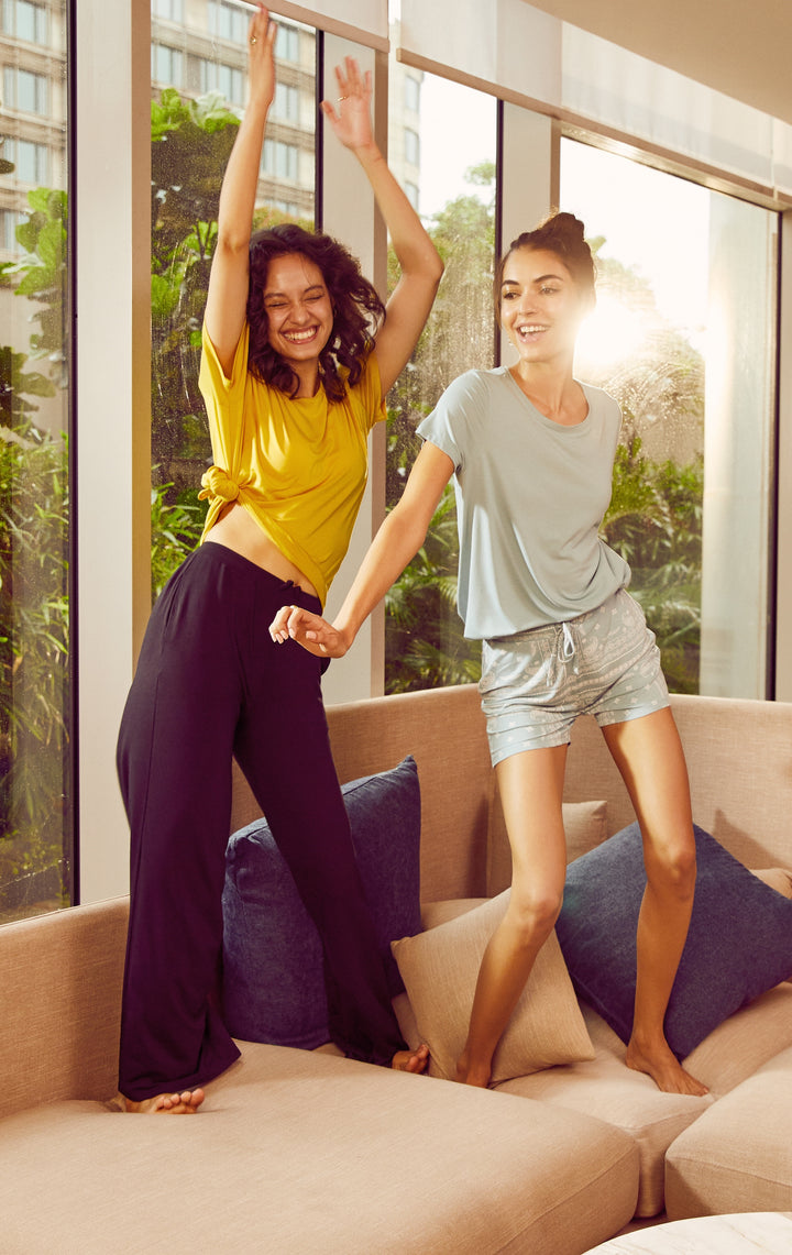 Two women dancing in stylish black flared lounge pants.
