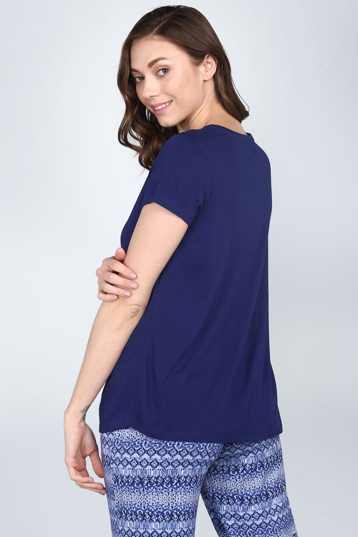 Woman showcasing Blue Tiger Capri Set, featuring stylish blue patterned pants.
