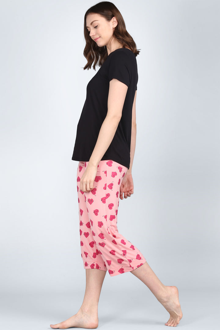 Everyday black top paired with playful pink heart pajamas.