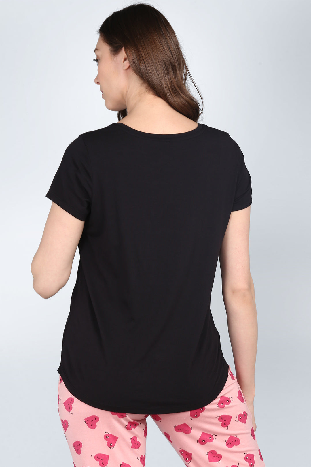 Back view of Nap Queen Pajamas featuring stylish black top and playful pink bottoms.