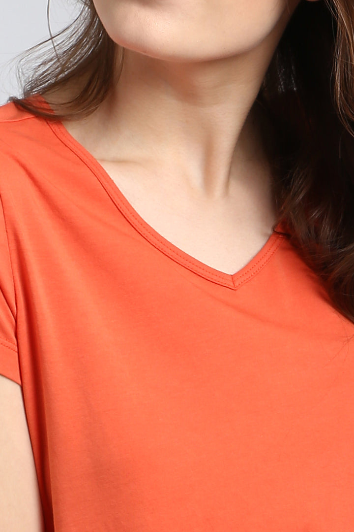 Close-up of woman wearing a Berry Blast Pajama Set in vibrant orange.