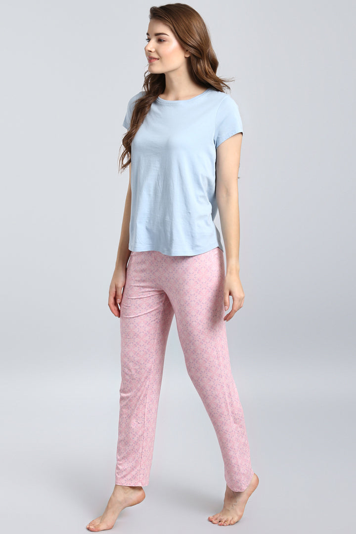 Woman wearing blush pattern pajama set in pastel colors.