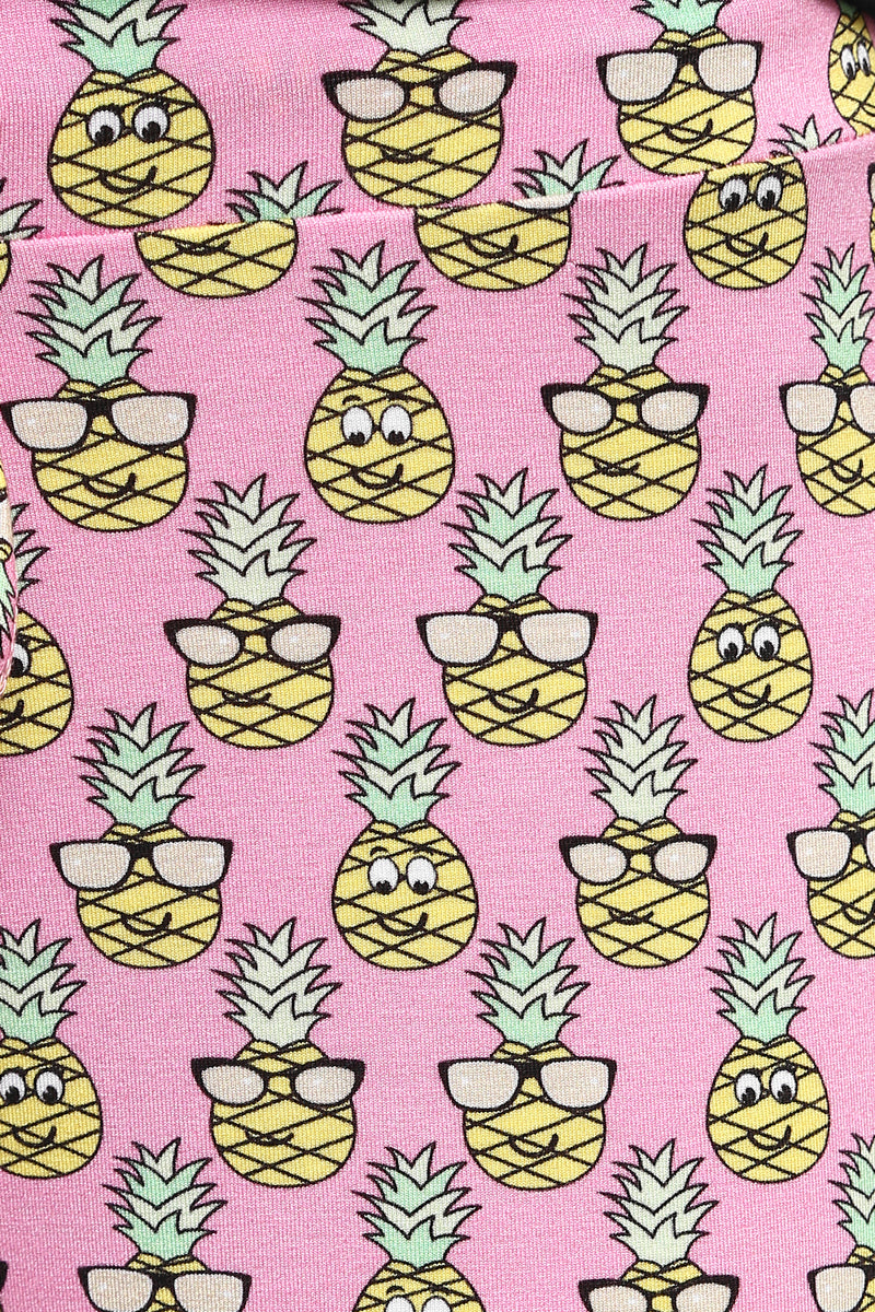 Cute pajama fabric with smiling pineapples on a pink background.