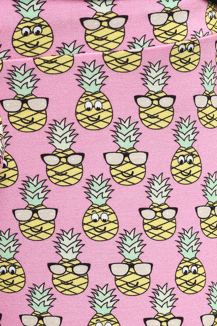 Cute pajama fabric with smiling pineapples on a pink background.