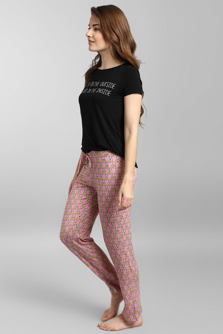 Model wearing Tropical Vacay Pajamas with black top and patterned pants.
