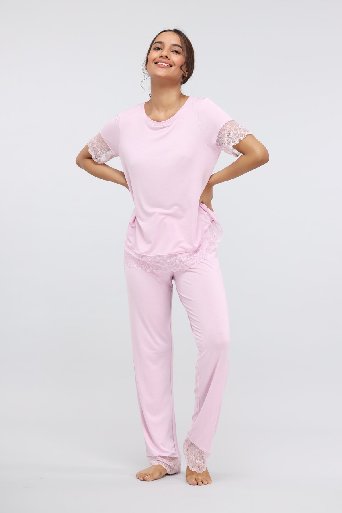 Soft pink modal lace pajama set worn by smiling woman.