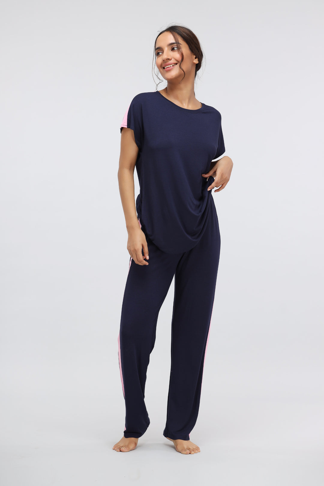 Woman wearing Blue Supima® pink stripe classic pajama set, smiling.