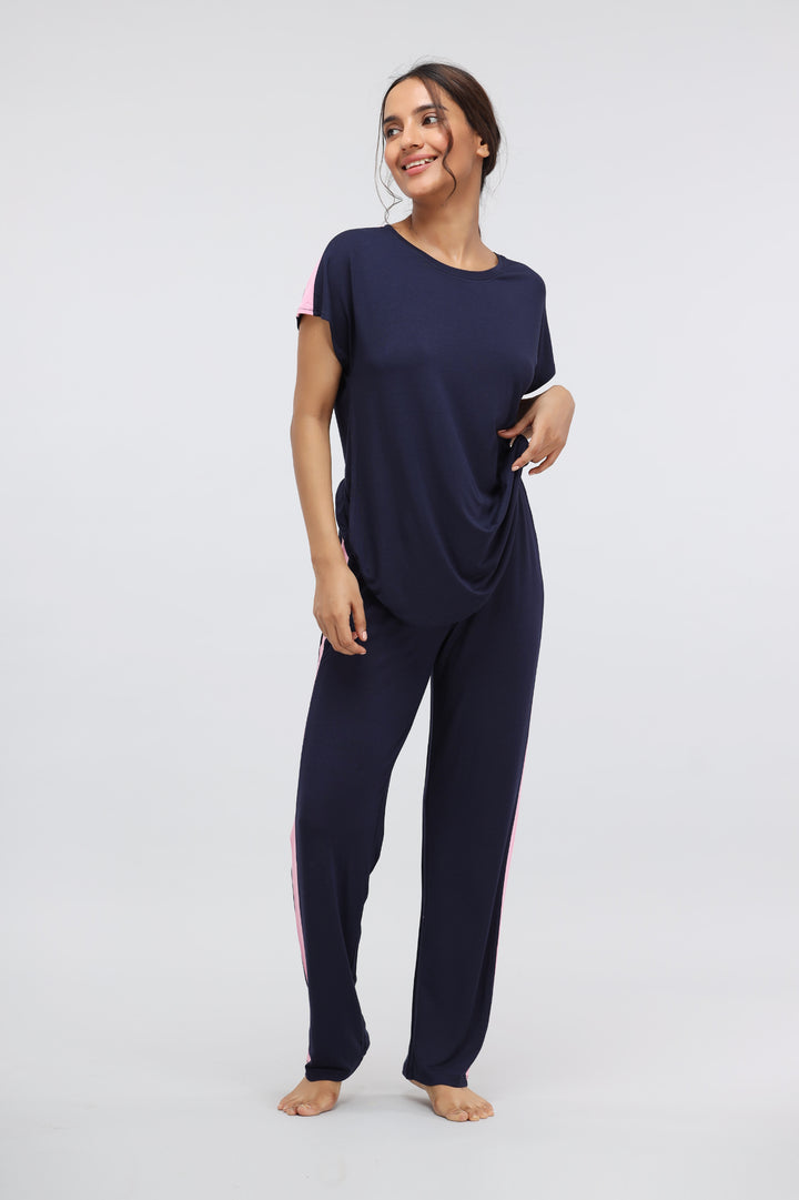 Woman wearing Blue Supima® pink stripe classic pajama set, smiling.